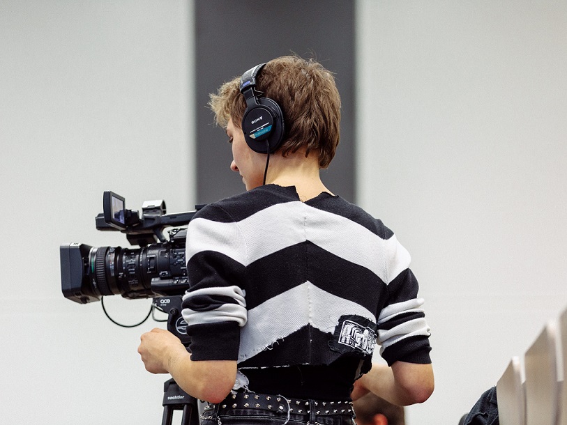 Back view of a person operating a film camera