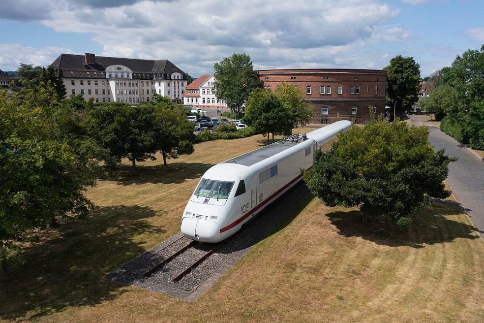 Train wagon stands on rails in a meadow