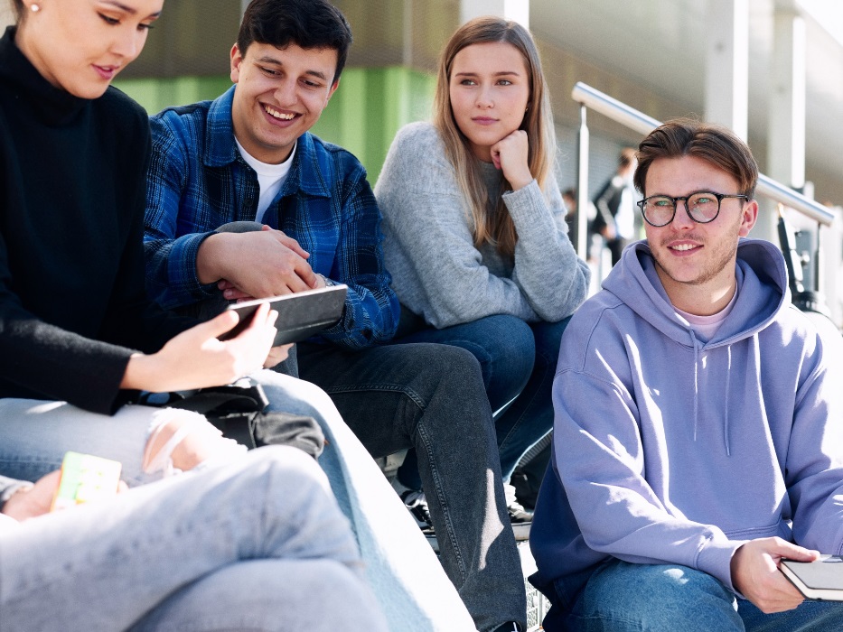 Studierende sitzen zusammen auf einer Treppe