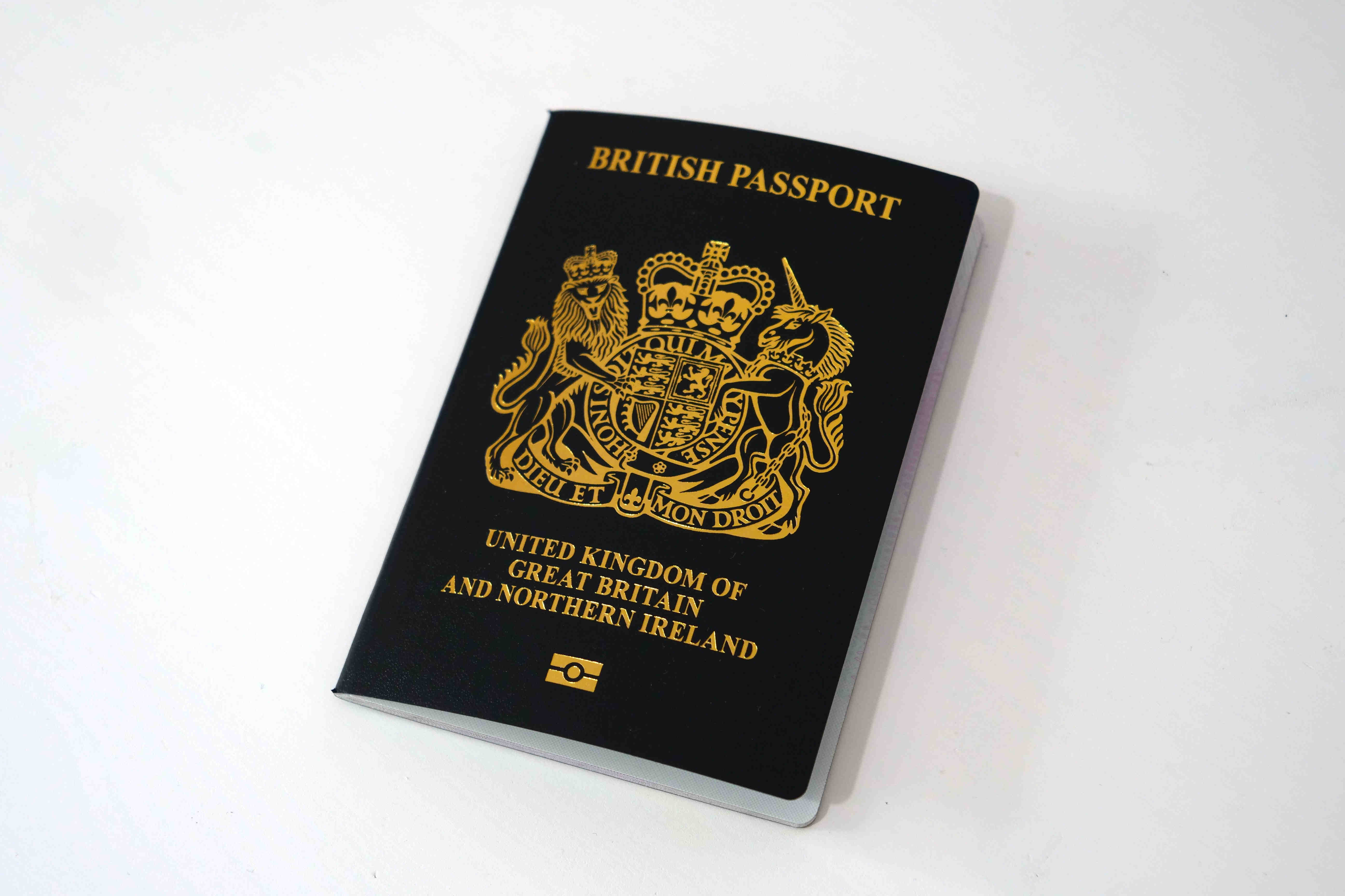 Blau-goldener Reisepass des Vereinigten Königreichs Großbritannien und Nordirland auf weißem Hintergrund