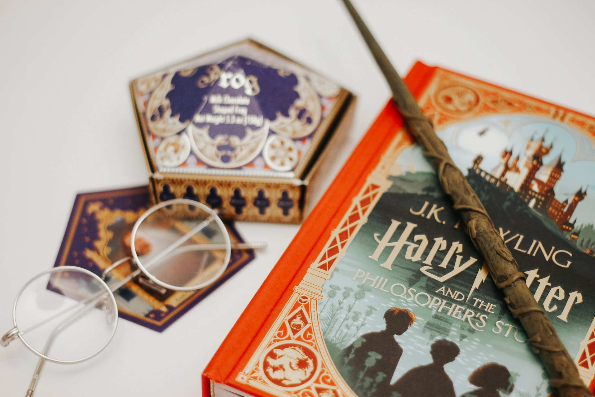 Der erste Harry Potter Band und Utensilien aus dem Universum: Ein Zauberstab, eine magische Süßigkeitenschachtel sowie die charakteristische Brille.