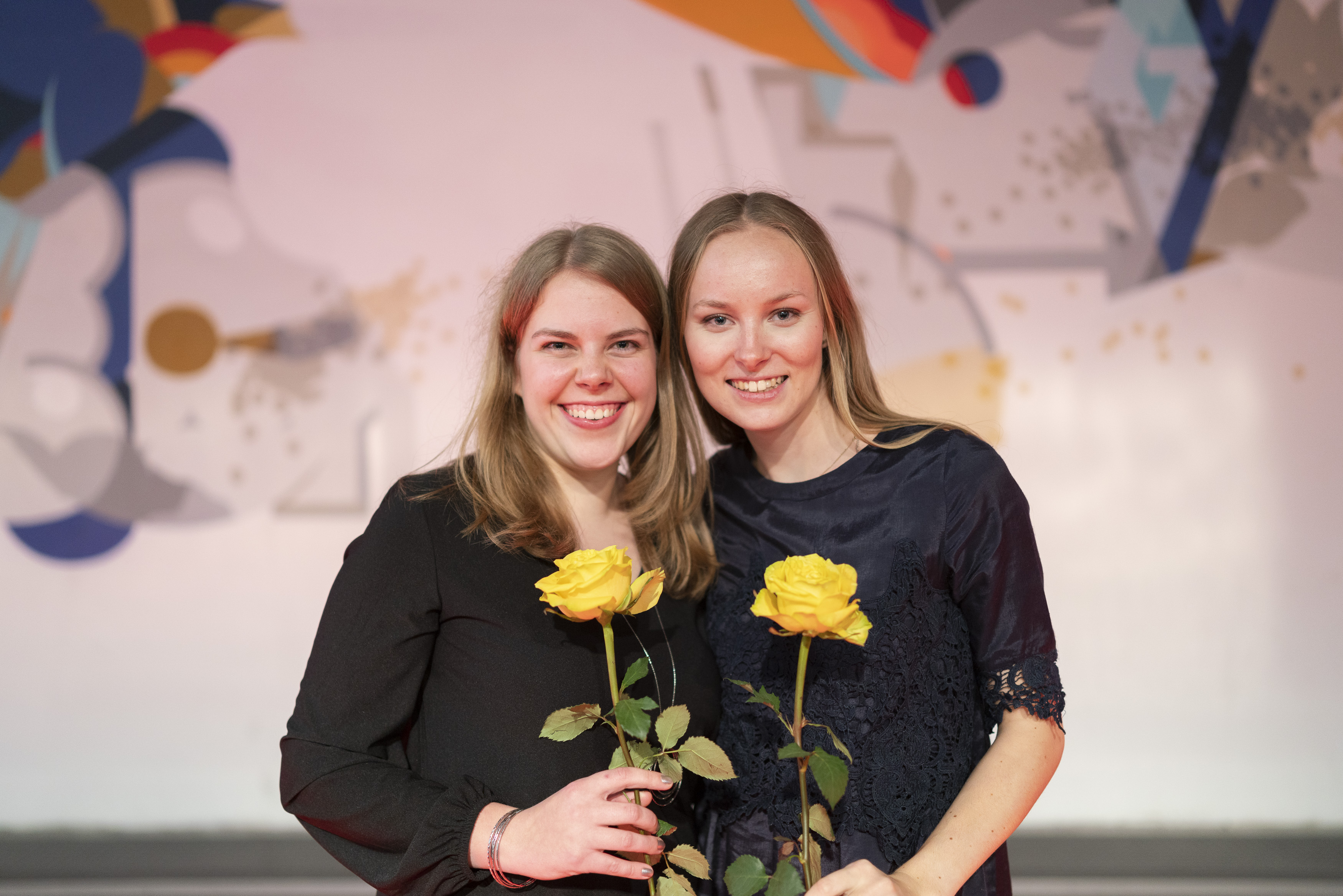 Zwei Absolventinnen mit Blumen