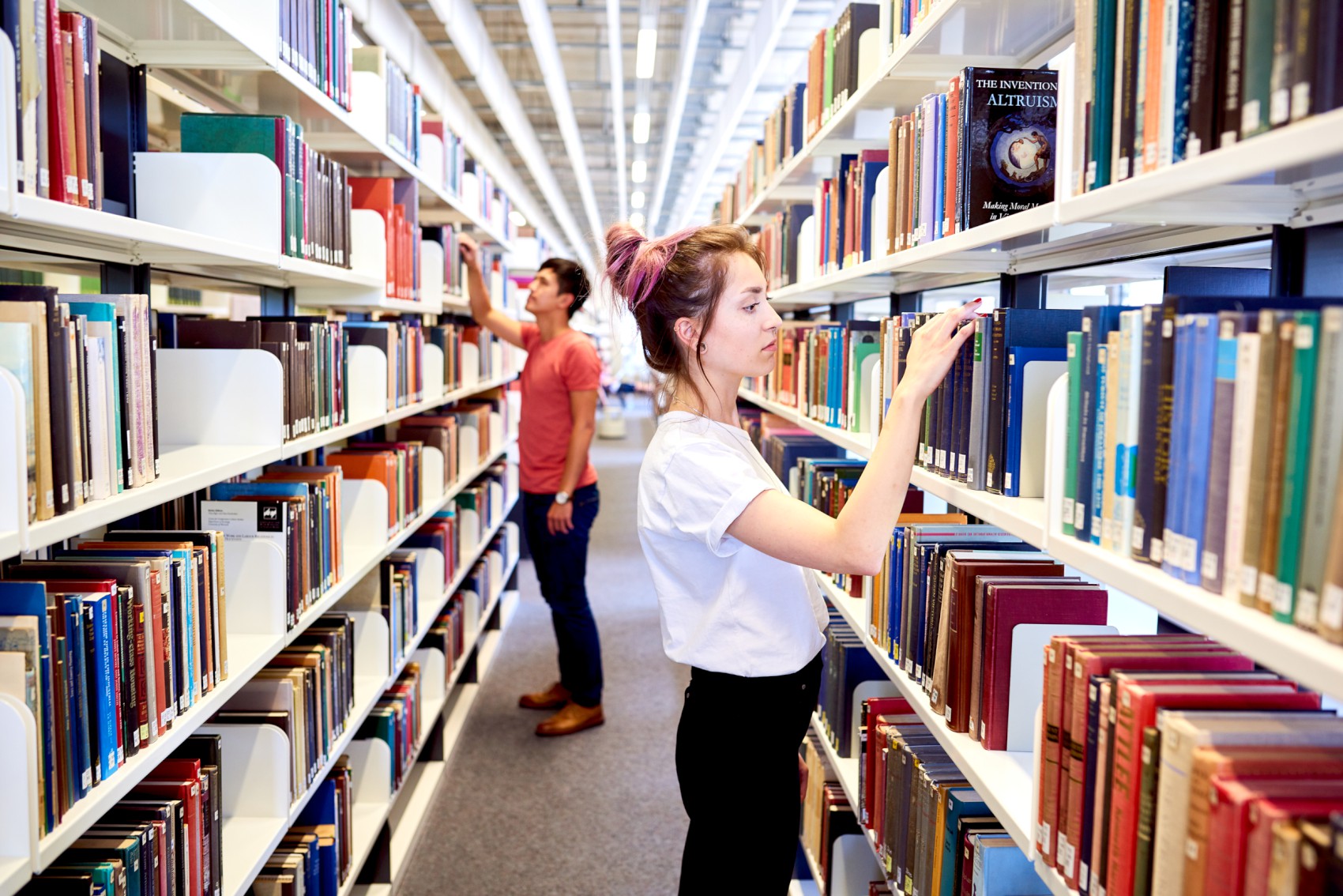 Studierende vor Bücherregal