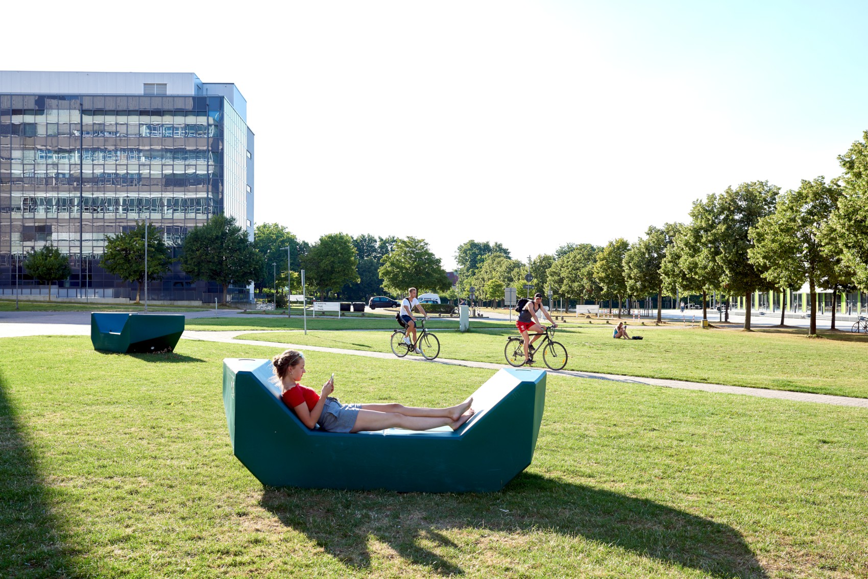 Studentin sitzt draußen auf der Wiese