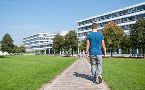 A person walks on one of the paths connecting the UHG with building X