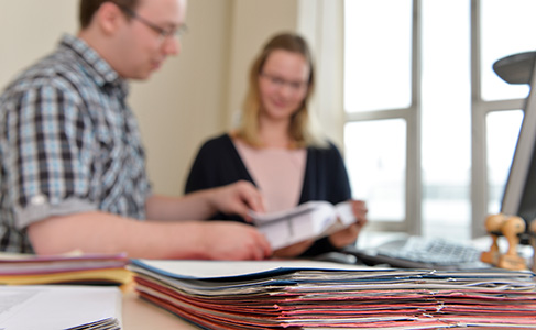 Zwei Personen am Schreibtisch sehen sich Bewerbungen an