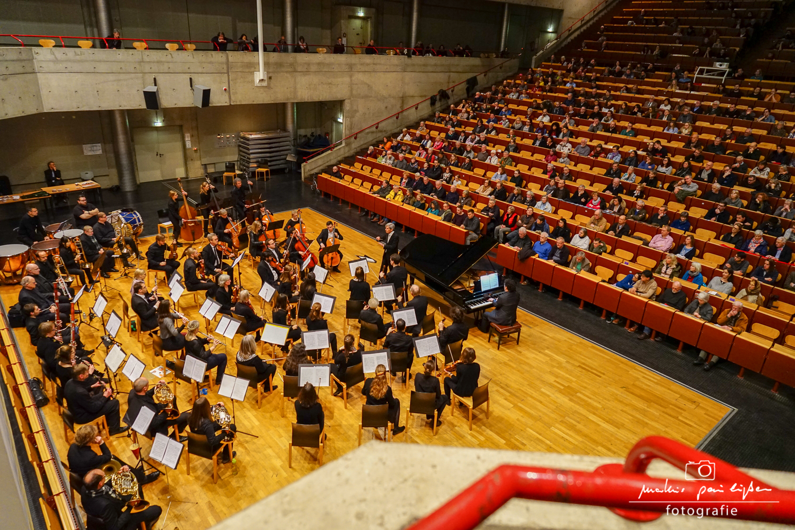 Blick von oben auf das Orchester, das im Audimax der Universität auftritt