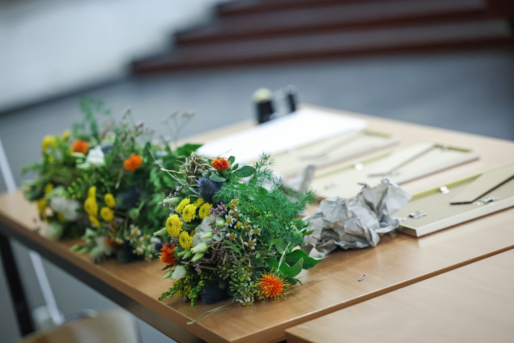 Blumen und Urkunden liegen auf dem Tisch bereit.