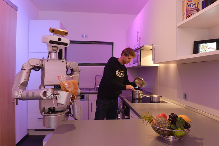 Human interacts with a robot in a kitchen