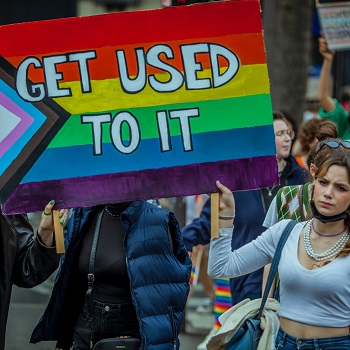 Demonstrierende Frauen, vorne ein Plakat mit Aufschrift "Get Used to It"